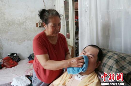 每次喂完食物后，梁青蘭都要仔細(xì)地幫兒子清理干凈?！∩忻鱾b 攝