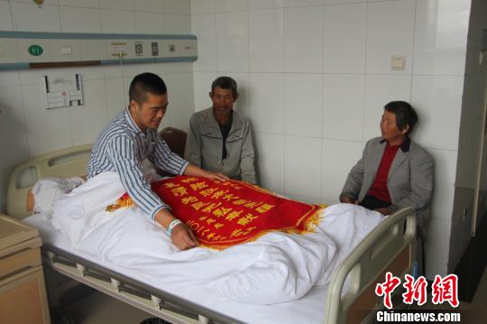 被救的李忠起、張總鳳夫婦看望受傷后的李運(yùn)飛。　汪渝 攝